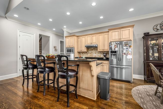 The kitchen blends elegance and function. Hardwood flooring adds durability and warmth, complementing the sleek design. | Image 38