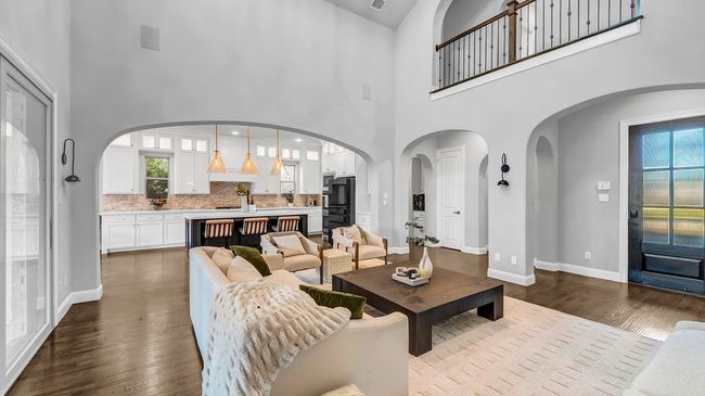 Living area featuring dark wood-type flooring, a healthy amount of sunlight, baseboards, and visible vents | Image 5