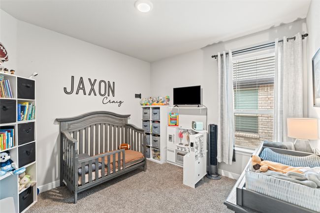 Carpeted bedroom featuring a nursery area and baseboards | Image 20