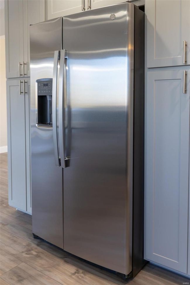 Kitchen with stainless steel fridge and wood-style flooring | Image 53