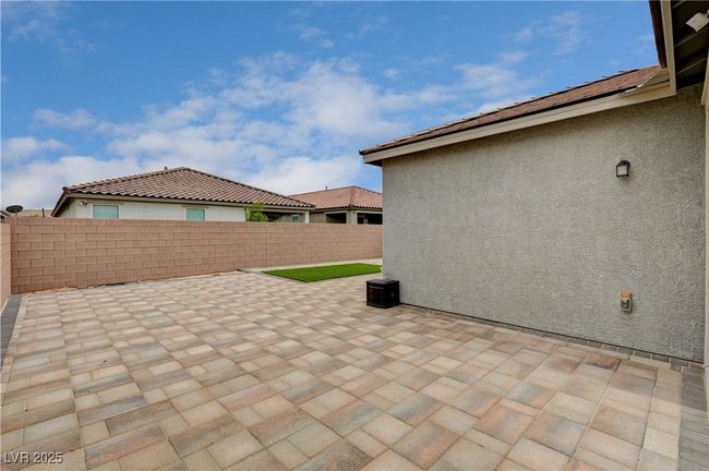 Fenced backyard with a patio | Image 34