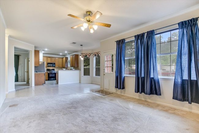 Unfurnished living room with ornamental molding, baseboards, ceiling fan, light colored carpet, and recessed lighting | Image 5