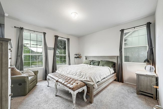 Large primary bedroom on the main floor with many windows for natural light. | Image 14