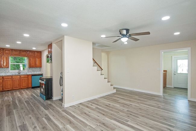 Kitchen with dishwasher, light wood-style flooring, recessed lighting, brown cabinets, and a ceiling fan | Image 7