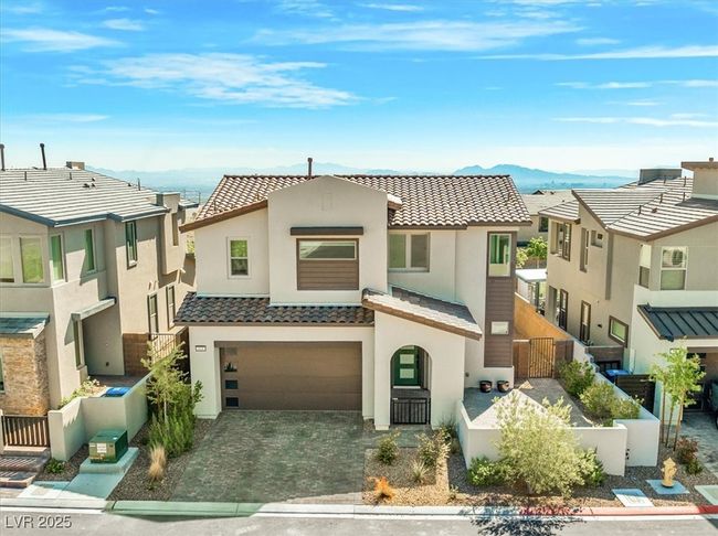 View of front of home with stucco siding, a fenced front yard, a tiled roof, decorative driveway, and a garage | Image 59