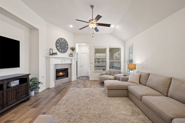 Comfortable and bright living room featuring a fireplace and scenic backyard views. | Image 19