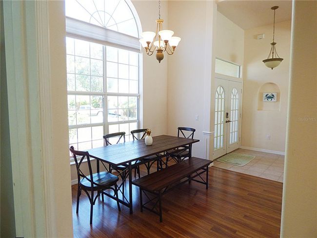 the formal dining area is very luminous thanks the high window and glass double door and transom window | Image 16