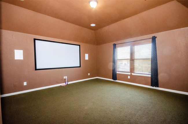 Cinema with baseboards, carpet, and lofted ceiling | Image 21