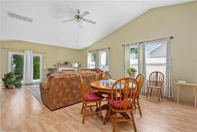 Dining space with lofted ceiling, plenty of natural light, ceiling fan, and light wood-type flooring | Image 3