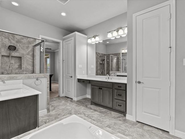 The primary en-suite bath features dual vanities, a soaking tub, walk-in shower and a large walk-in closet | Image 22