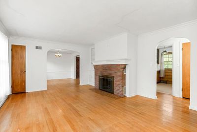 Unfurnished living room with a fireplace, wood-type flooring, and ornamental molding | Image 3