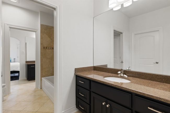 Full bath featuring vanity, tile patterned flooring, ensuite bathroom, and tub / shower combination | Image 24
