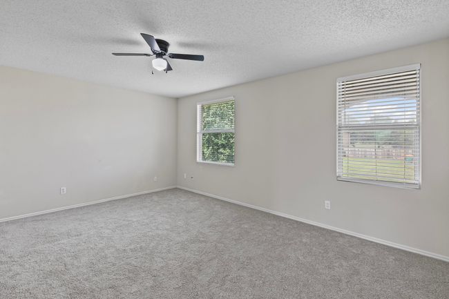 Spare room with a textured ceiling, a ceiling fan, and carpet floors | Image 10