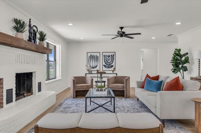 Living area featuring ceiling fan, ornamental molding, recessed lighting, wood finished floors, and a brick fireplace | Image 12