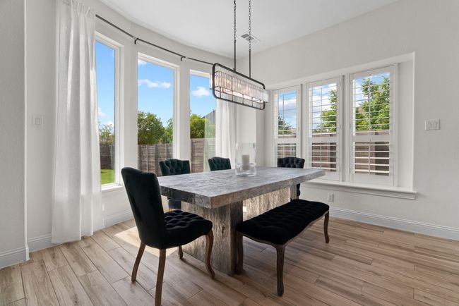 Dining space with healthy amount of natural light, baseboards, and light wood-type flooring | Image 13