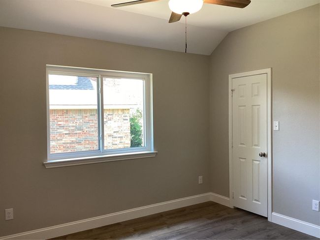 Unfurnished room with a ceiling fan, dark wood-type flooring, and lofted ceiling | Image 26