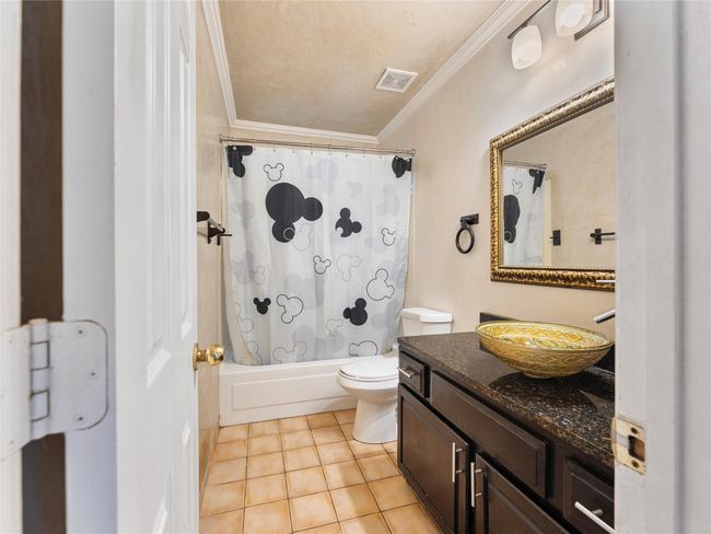 Bathroom with vanity, crown molding, tile patterned floors, and shower / bath combination with curtain | Image 18