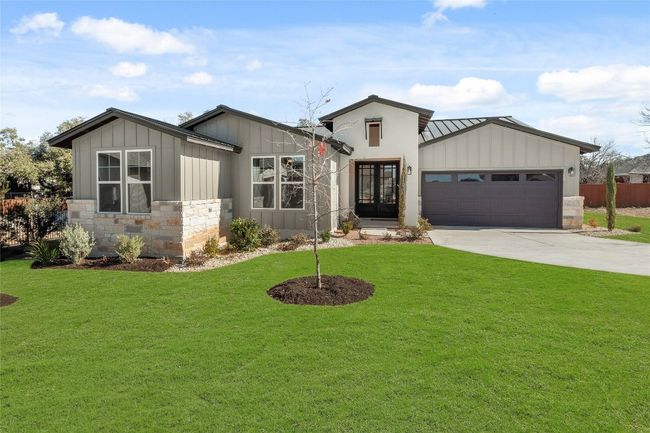 View of front of home with board and batten siding, french doors, stone siding, and a front lawn | Image 30