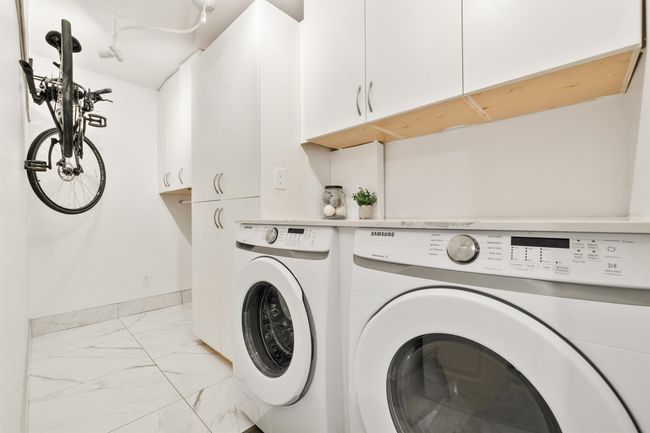 Washroom featuring marble finish floor, cabinet space, baseboards, and washer and dryer | Image 22