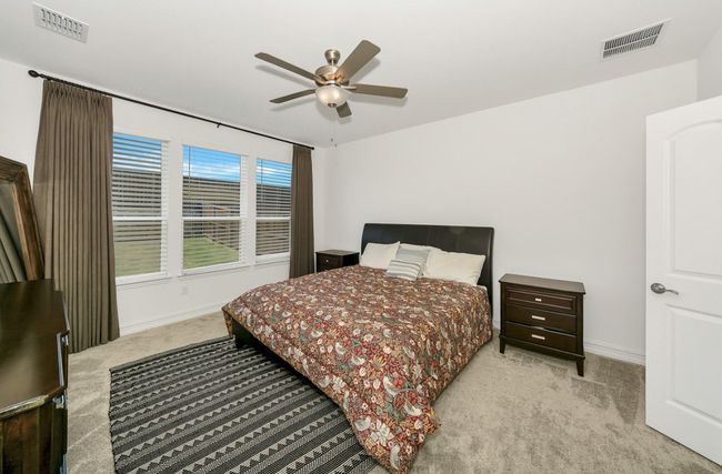 Carpeted bedroom featuring visible vents, baseboards, and ceiling fan | Image 13