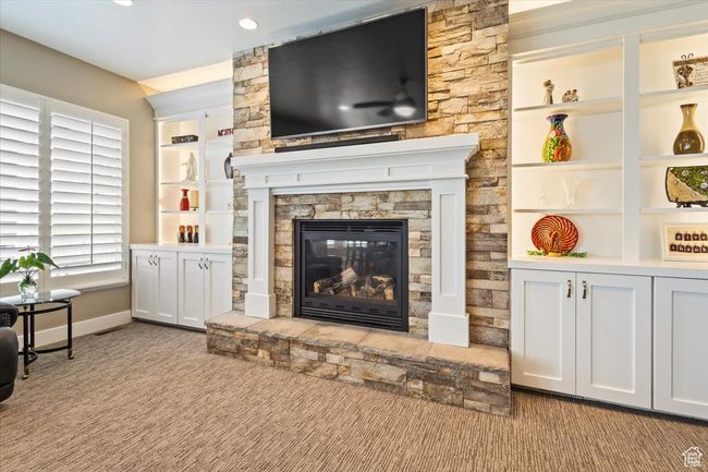 Living area featuring a stone fireplace, baseboards, carpet, recessed lighting, and built in features | Image 14