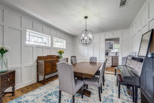 Dining room with a decorative wall, a chandelier, and light wood-style flooring | Image 8