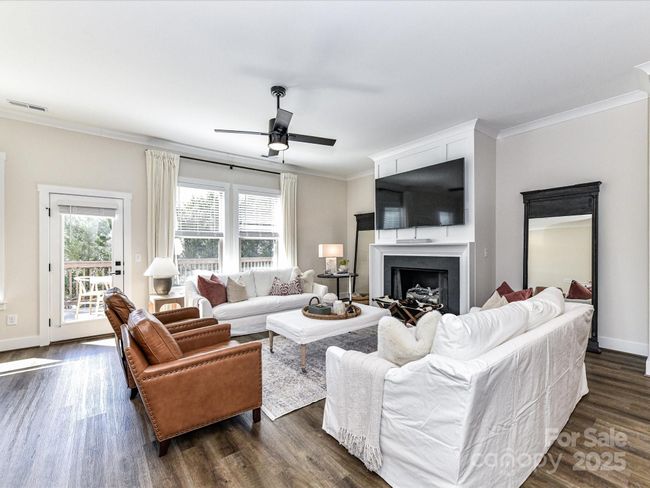 Great Room offers crown molding, cozy fireplace with gas logs, ceiling fan/light, deck access & LVP floors! | Image 13