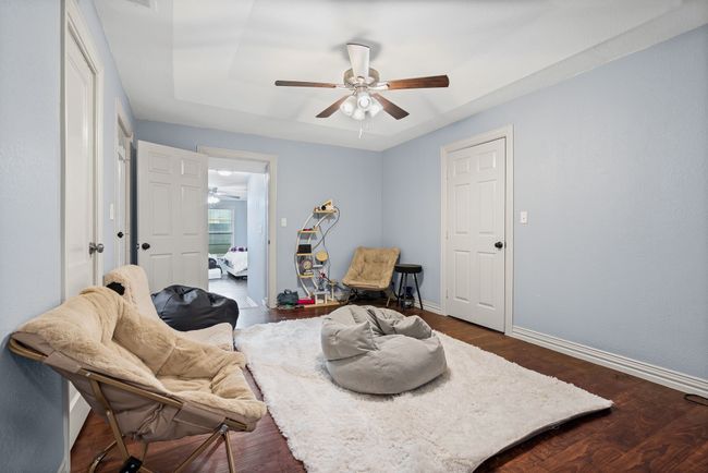 Living area featuring ceiling fan and dark wood-style floors | Image 17