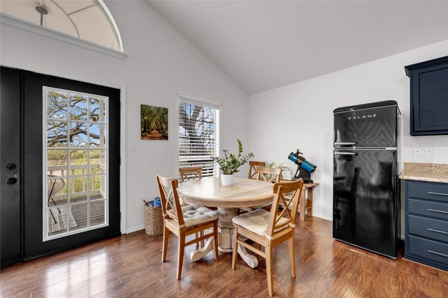 Dining area featuring dark wood-style floors, baseboards, and vaulted ceiling | Image 12