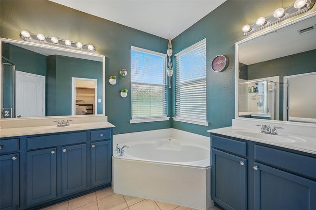 Bathroom with two vanities, a garden tub, a shower stall, and tile patterned flooring | Image 19