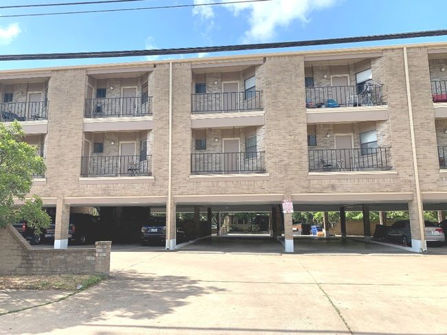 View of apartment building / complex with covered parking | Image 12
