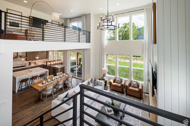 Living area with wood finished floors, a chandelier, a towering ceiling, and recessed lighting | Image 16