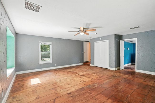 Unfurnished bedroom featuring hardwood / wood-style flooring and a ceiling fan | Image 24