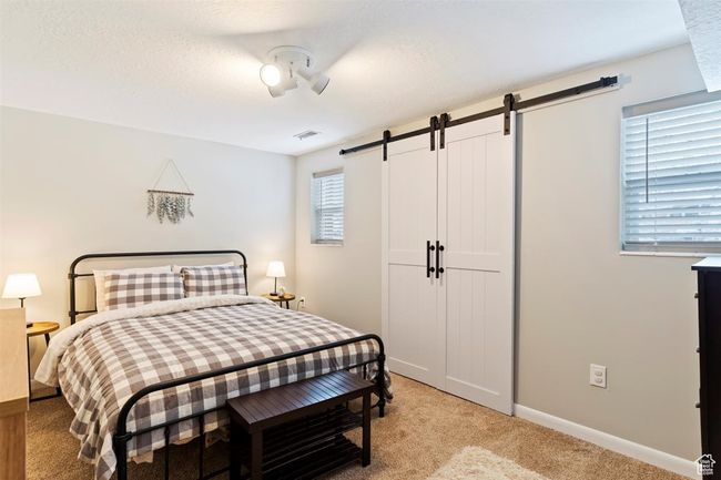 Bedroom featuring a barn door, light carpet, and baseboards | Image 25
