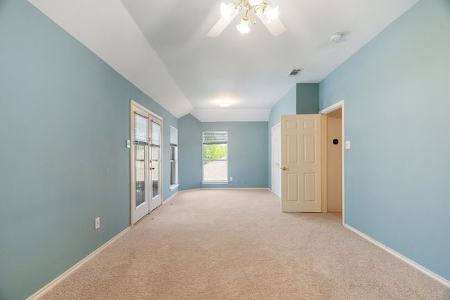 Empty room with light carpet, visible vents, baseboards, and a ceiling fan | Image 22
