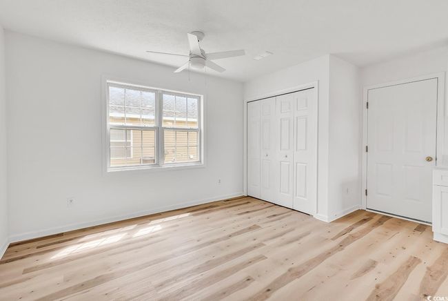 Unfurnished bedroom featuring baseboards, a ceiling fan, a closet, and light wood-style flooring | Image 11