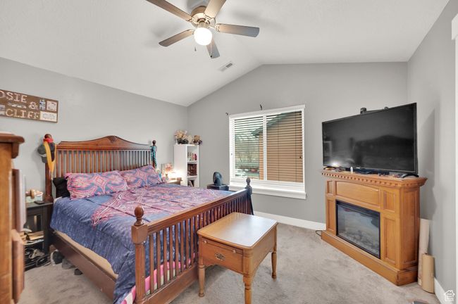 Bedroom with lofted ceiling, light carpet, and ceiling fan | Image 8