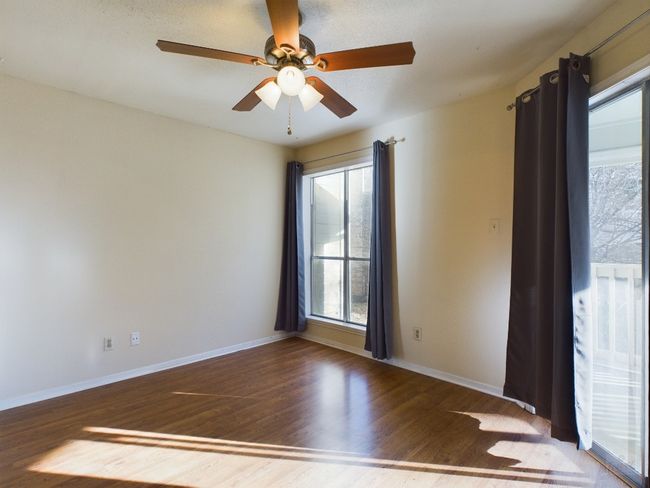 Empty room featuring wood finished floors, ceiling fan, and baseboards | Image 12