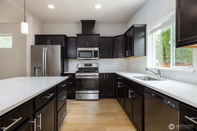 Kitchen has spacious island with eating bar. | Image 10