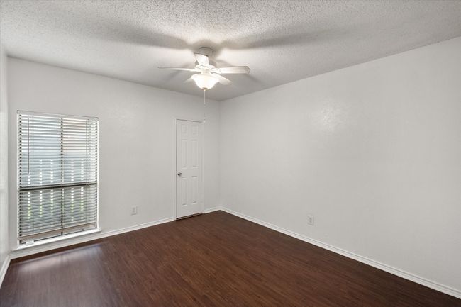 Spare room with ceiling fan, dark wood finished floors, and a textured ceiling | Image 15