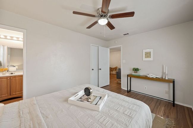 Ceiling fan and new flooring welcome you to this clean and inviting primary bedroom. | Image 18