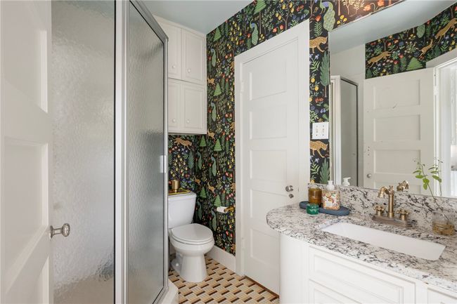 Bathroom with wallpapered walls, a stall shower, vanity, and toilet | Image 19