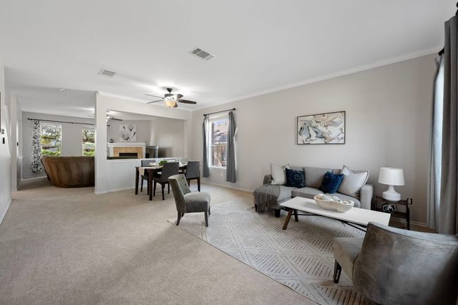 Living room featuring a tile fireplace, light colored carpet, ceiling fan, crown molding, and baseboards | Image 4