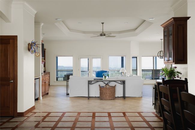 Living area featuring ceiling fan, healthy amount of natural light, a tray ceiling, and recessed lighting | Image 17