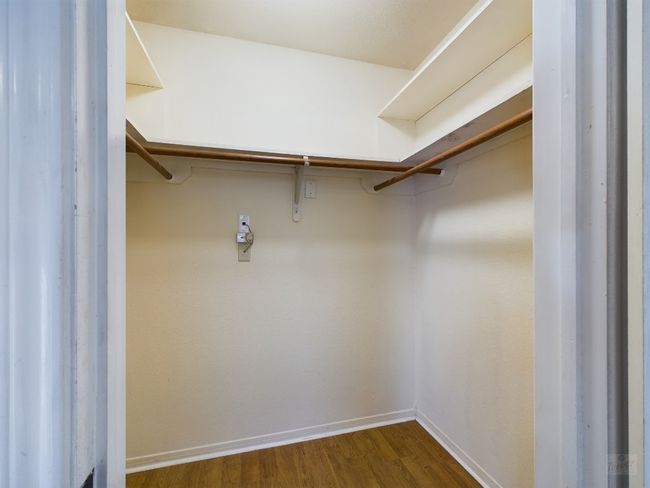 Walk in closet with dark wood-style flooring | Image 13