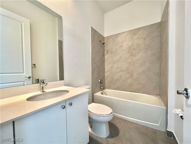 Full bathroom with tiled / bath tube, vanity, toilet, and tile patterned flooring | Image 23