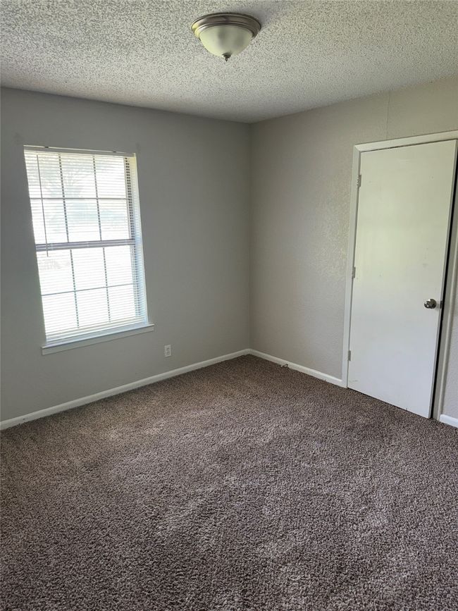Unfurnished room featuring carpet floors, a textured ceiling, and baseboards | Image 8