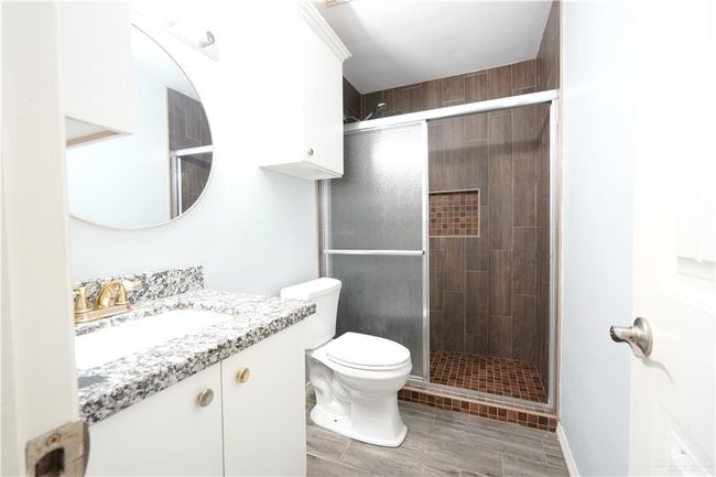 Full bath featuring vanity, a shower stall, and wood finished floors | Image 13