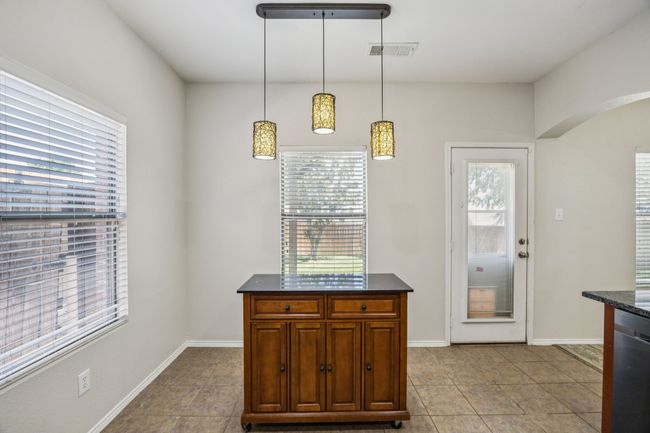 Kitchen featuring dark countertops, healthy amount of natural light, and arched walkways | Image 13