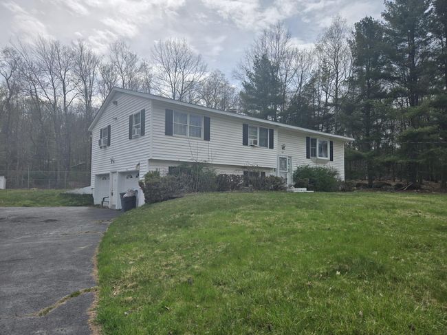 Bi-level home featuring a garage, fence, aphalt driveway, and a front yard | Image 5